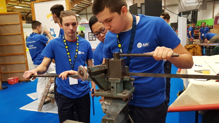 des jeunes au salon Ain'Formations Orientation, deux d'entre eux regardent un autre utiliser un outil