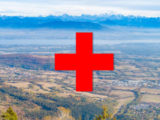 paysage du pays de gex sur lequel on voit le symbole "+" rouge de l'Hopital rouge