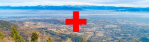 paysage du pays de gex sur lequel on voit le symbole "+" rouge de l'Hopital rouge