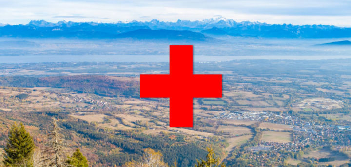 paysage du pays de gex sur lequel on voit le symbole "+" rouge de l'Hopital rouge