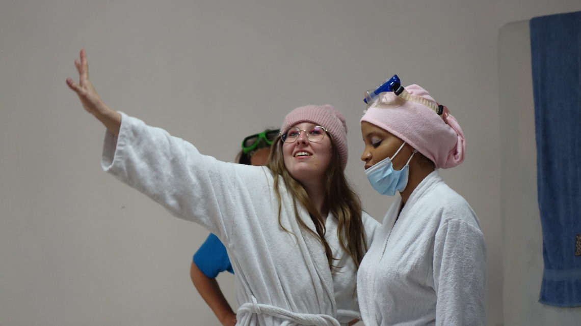 deux jeunes actrices du groupe Théatricité, en train de jouer avec des accessoires sur la tête et en peignoir