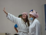 deux jeunes actrices du groupe Théatricité, en train de jouer avec des accessoires sur la tête et en peignoir