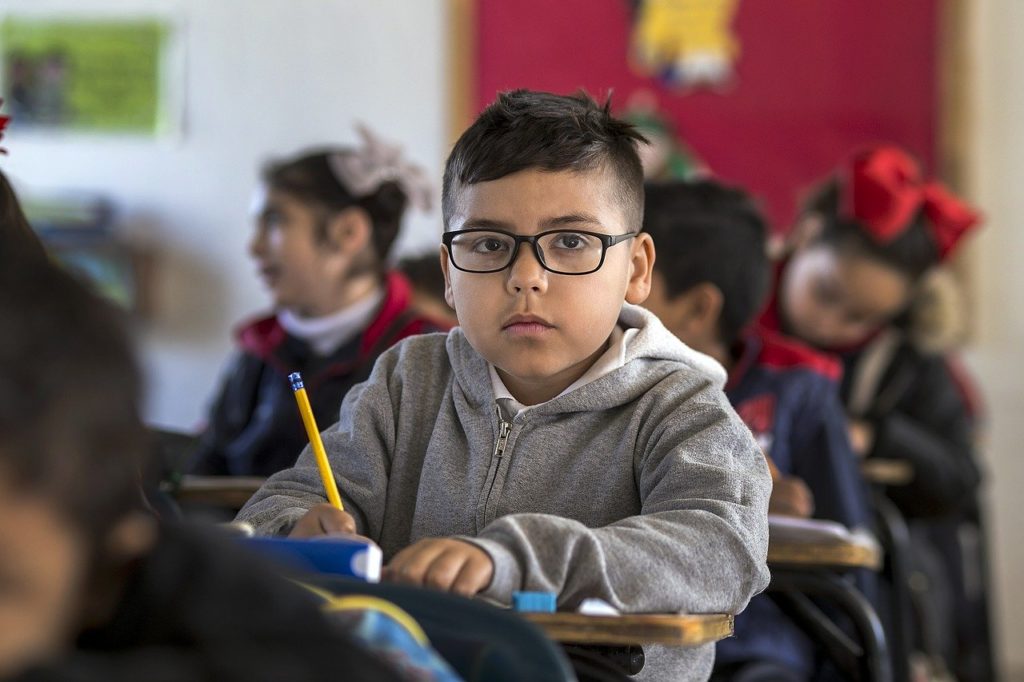 une classe d'élèves d'une dizaine d'années, en train d'écrire dans leurs cahiers