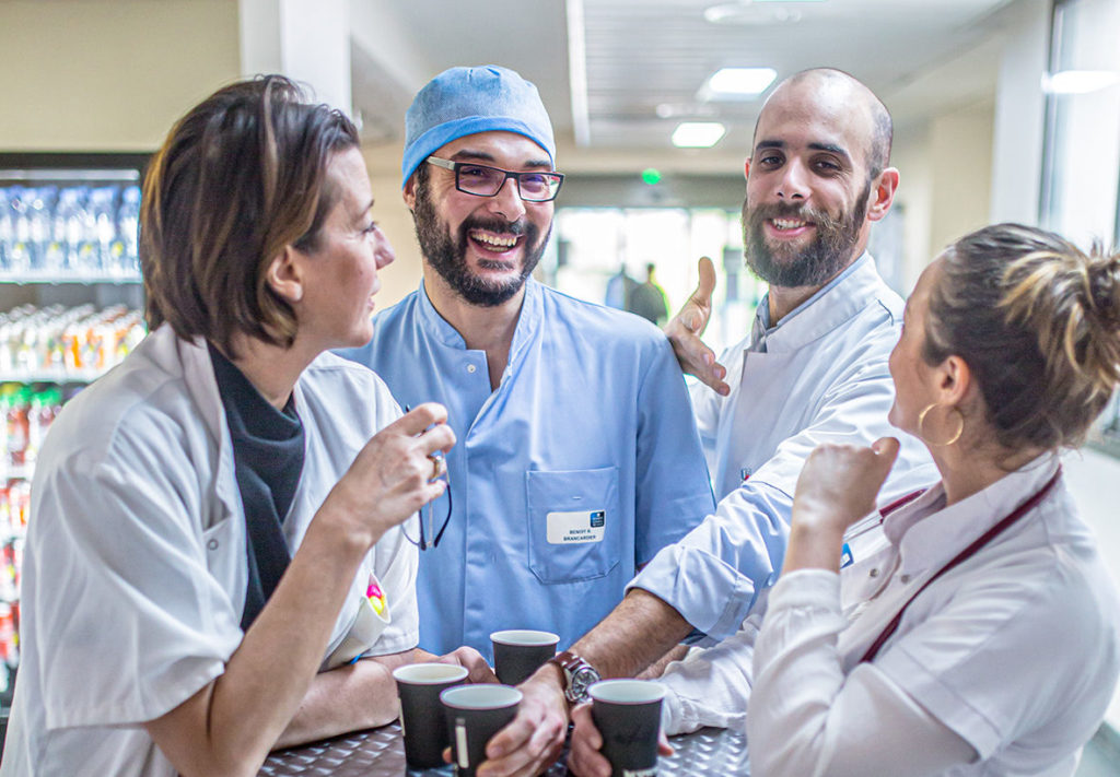 Des médecins prennent leur pause café ensemble et rient