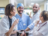 Des médecins prennent leur pause café ensemble et rient