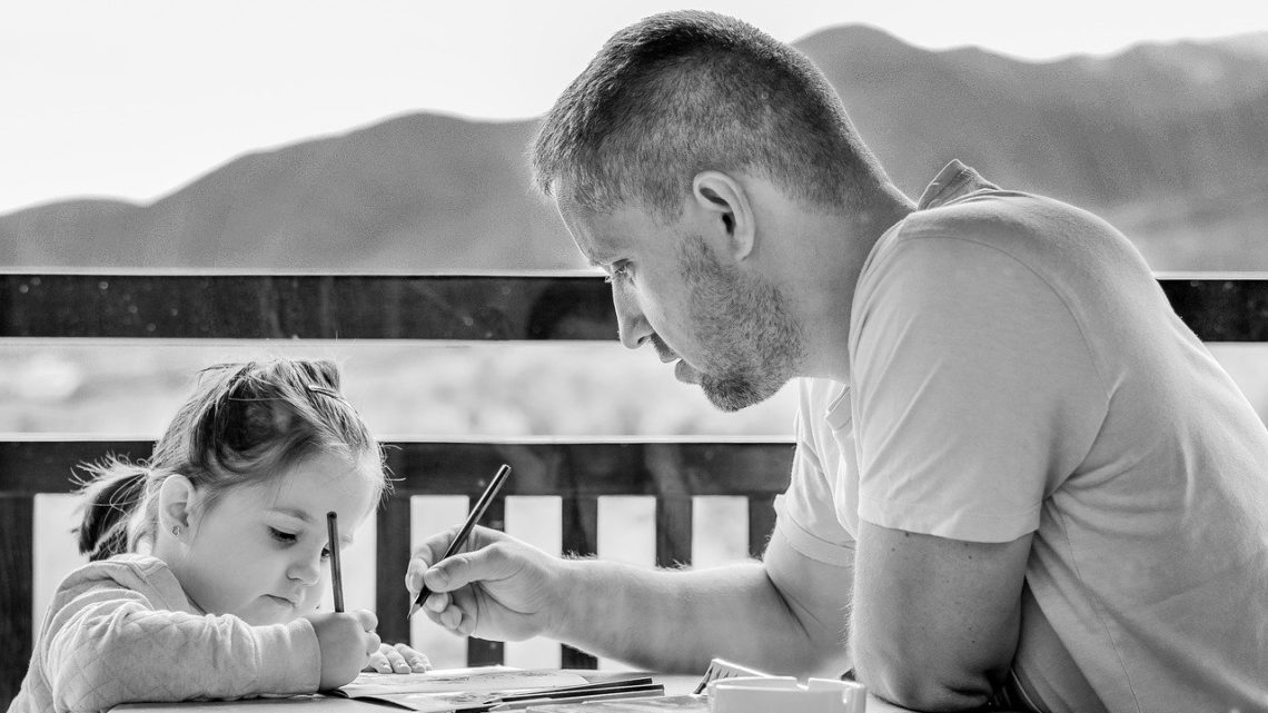 Sur un balcon, un père s'occupe de sa petite fille en dessinant avec elle.