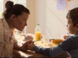 Image extraite du film "La vraie famille", la mère d'accueil tient la main du garçon lors d'un petit déjeuner.