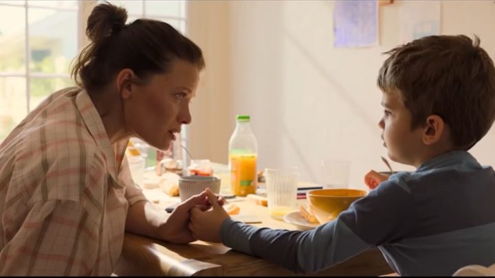 Image extraite du film "La vraie famille", la mère d'accueil tient la main du garçon lors d'un petit déjeuner.