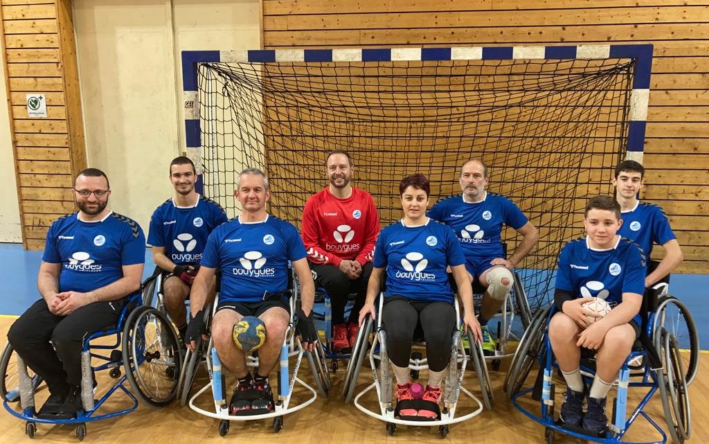 8 personnes posent devant la cage; c'est le groupe de hand fauteuil du club HB Meximieux