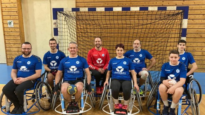 8 personnes posent devant la cage; c'est le groupe de hand fauteuil du club HB Meximieux