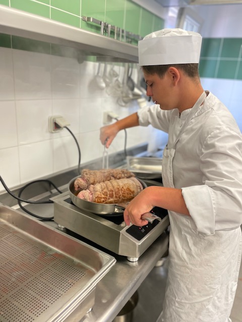 un jeune cuisinier est en train de cuire des gigots