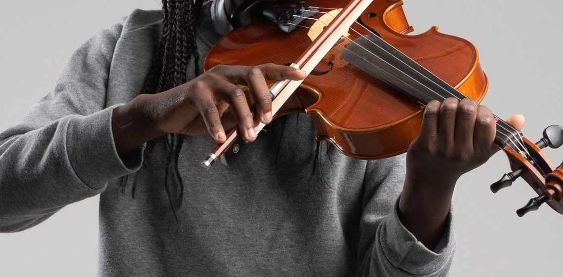image centrée sur le buste et les bras d'un musicien jouant du violon