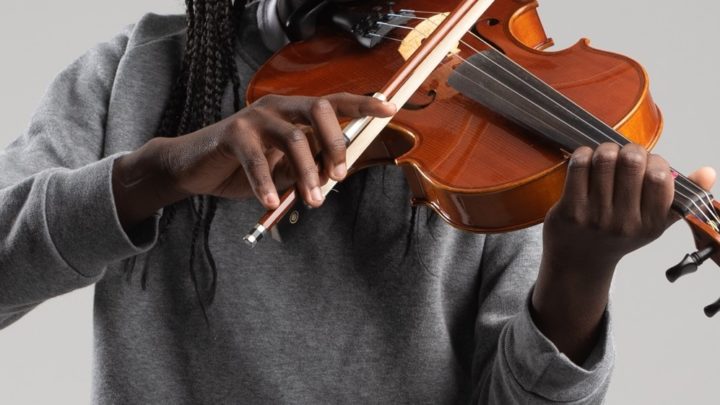 image centrée sur le buste et les bras d'un musicien jouant du violon