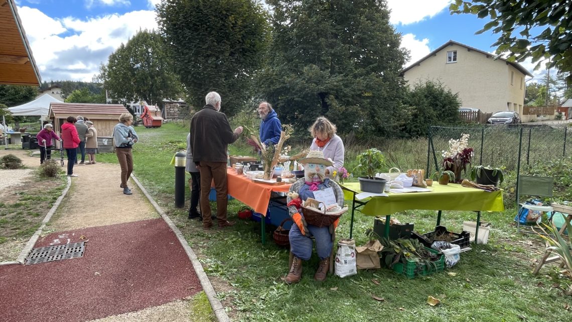 Plusieurs personnes discutent autour du stand sur le "Secret des plantes" organisé par la Marpa Les Narcisses, à Brénod.