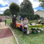 Plusieurs personnes discutent autour du stand sur le "Secret des plantes" organisé par la Marpa Les Narcisses, à Brénod.