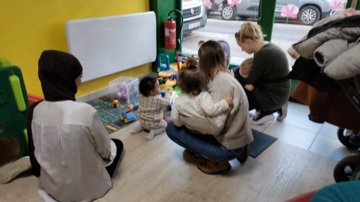 Parents et enfants sont accroupis pour jouer au LAEP Jeunes Pousses à Bourg-en-Bresse