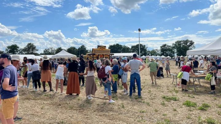 La fête annuelle de l'association des agriculteurs sourds de France a eu lieu cette année dans l'Ain, et a attiré beaucoup de monde. on voit des centaines de personnes présentes dans un champs sous le ciel bleu