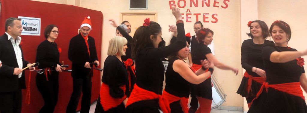 Culture et santé : À l’IME La Côtière, la compagnie des Zurbamateurs dansent la batucada et jouent des percussions et autres instruments dans une salle. Ils sont tous habillés en noir et rouge.